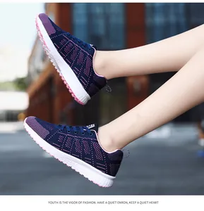 Close-up of lightweight navy blue breathable flyknit sneakers for women in a street setting
