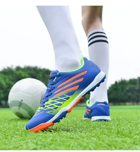 Levendige blauwe en groene voetbalschoenen gedragen door een speler op het grasveld