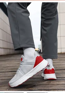 Close-up view of men's breathable mesh running shoes with gray upper and red accents.