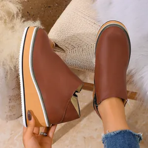 Vue détaillée de bottines marron à talons compensés avec fermeture éclair et semelle rayée
