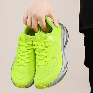 Detailed close-up of neon green breathable flyknit running shoes held by hand for display