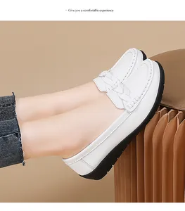 Side view of comfortable white leather loafers with braided strap detail and black sole.