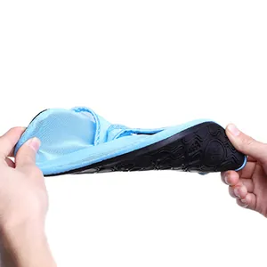 Detailed view of a flexible light blue water shoe being easily bent by hands on white background