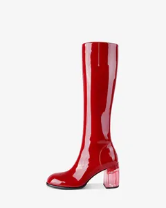 Detailed view of glossy red patent leather knee-high boot with a clear pink chunky heel.