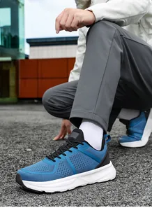 Detail shot of blue breathable mesh men's sports shoes with wide-fit cushioning sole.