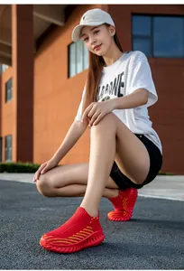 Red fly-knit slip-on sneakers for women in a street lifestyle outdoor setting