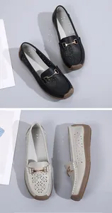 Detalle de mocasines de cuero para mujer con corte láser floral y hebilla metálica dorada