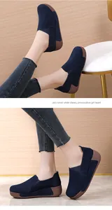 Detailed view of navy blue suede platform loafers with textured brown rocker soles