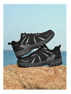 Black breathable hiking shoes stacked on a rock with a scenic ocean background
