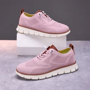 Detail view of women's pink fly-knit sneakers with breathable mesh and white soles.