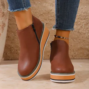 Bottines marron pour femmes à bout rond avec semelle compensée et fermeture éclair.