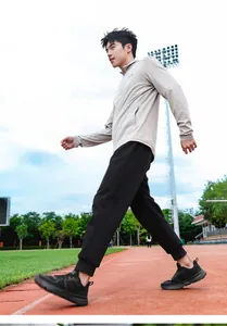Asian male athlete walking on track in black wide last breathable mesh running shoes