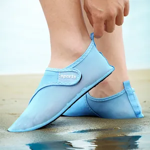 Close-up of breathable light blue quick-dry aqua shoes with mesh design on sandy beach