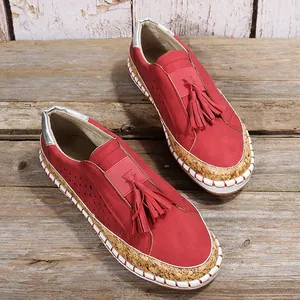 Vue de dessus de chaussures plates rouges avec glands décoratifs et semelles en liège