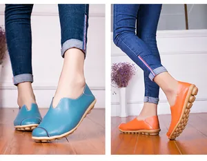 Tweeluik van blauwe en oranje leren instappers gedragen aan de voeten van het model