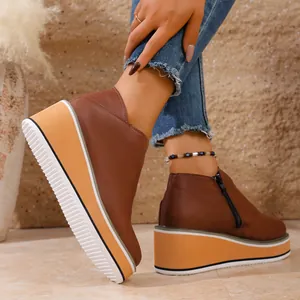 Vue détaillée de bottines marron à talons compensés avec fermeture éclair latérale