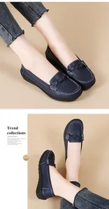 Detailed view of navy blue loafers with contrast stitching and woven bow design
