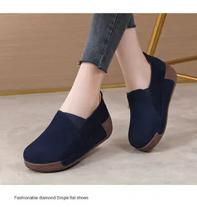 Close-up detail view of navy blue suede platform rocker shoes worn by an Asian model.