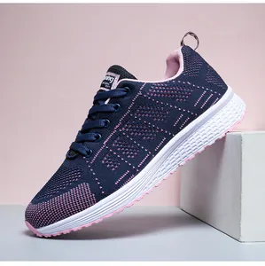 Detail view of navy blue and pink breathable fly-knit athletic running shoes for women.