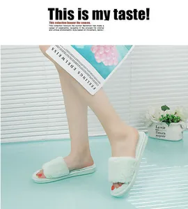 Close-up detail of plush light green open-toe slides in a stylish indoor lifestyle setting