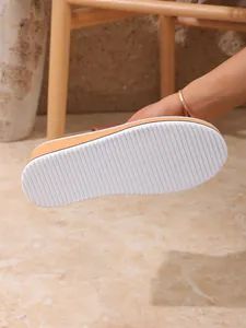 Gros plan de la semelle en caoutchouc blanc antidérapante de ces bottines compensées