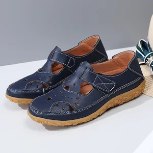 Close-up view of navy blue hollow-out leather sandals with intricate floral stitching details