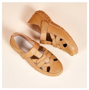 Top-down view of tan summer beach sandals with hollowed-out cross straps and soft sole
