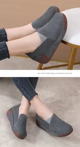 Detailed view of grey suede slip-on shoes with thick wedge soles on a fashion model