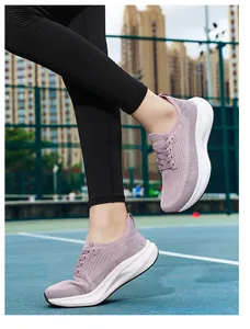 Women's pink flyknit running shoes with wide toe box on tennis court