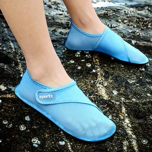 Macro detail of breathable light blue mesh beach water shoes worn on a rocky ocean shore