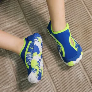 Enfant portant des chaussures d'eau antidérapantes bleu et vert sur un sol carrelé