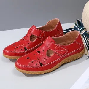 Detailed macro view of red leather hollow out flat sandals with floral pattern rubber sole