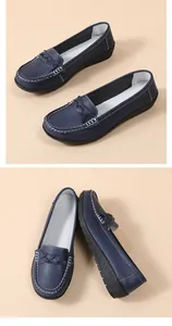 Detail view of navy blue flat loafers for women with textured leather and white stitching