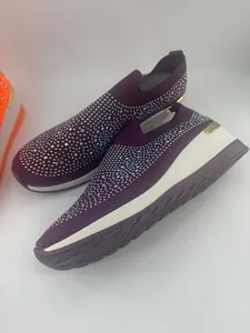 Detalle de las elegantes zapatillas de cuña moradas con adornos de strass brillantes