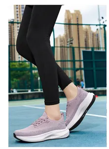 Detailed side view of women's purple breathable knit running shoes on an outdoor court