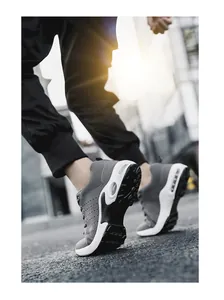 Detail view of grey fly-knit men's sneakers with air cushion sole on street
