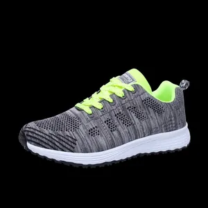 Side view detail of breathable grey flyknit running shoe with neon green laces.