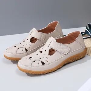 Detailed view of stylish women's beige hollow-out leather flat sandals with adjustable strap
