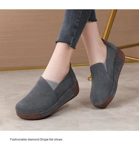 Close-up of grey suede platform rocker shoes worn with denim jeans in a home setting