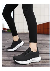 Detailed close-up of black breathable mesh running shoes for women on a wooden floor