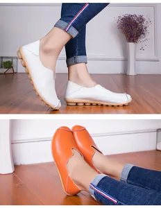 Detailweergave van platte lederen damesloafers in wit en oranje met zachte zolen