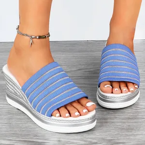 Nahaufnahme von blauen Keilsandaletten aus Fly-Knit mit komfortabler Plateausohle.