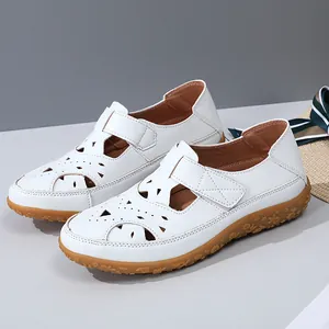Close-up of white women's hollow-out sandals with durable gum sole and velcro strap