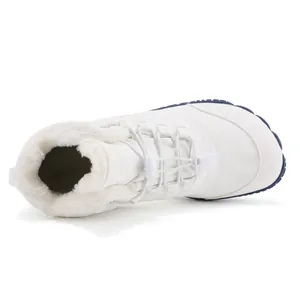 Vista superior de botas de invierno blancas de pies descalzos con forro de felpa.