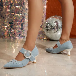 Detailaufnahme von hellblauen Denim-Kitten-Heels mit glitzernder Strass-Schnalle.