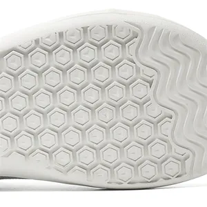 Close-up detail of the anti-slip hexagonal and wavy pattern on a white shoe sole
