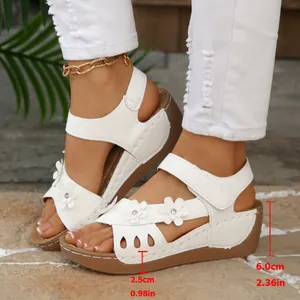 Detailansicht weißer Damen-Keilsandalen mit Blumenakzenten und 6 cm Absatzhöhe.