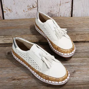 Gros plan détaillé de mocassins plats blancs élégants avec glands et semelles en liège