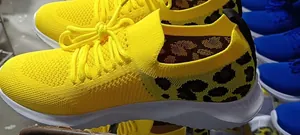 Detailed view of women's yellow mesh sneakers featuring stylish leopard print heels
