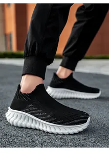 Close-up of black breathable fly-knit slip-on sneakers with white textured sole